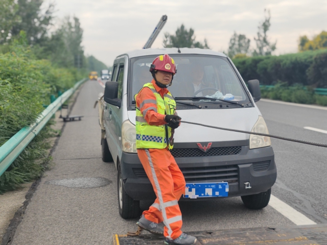 亳州中心阜陽段上行K376施救員徐建才調(diào)整拖車鋼絲繩，開展救援行動。.jpg